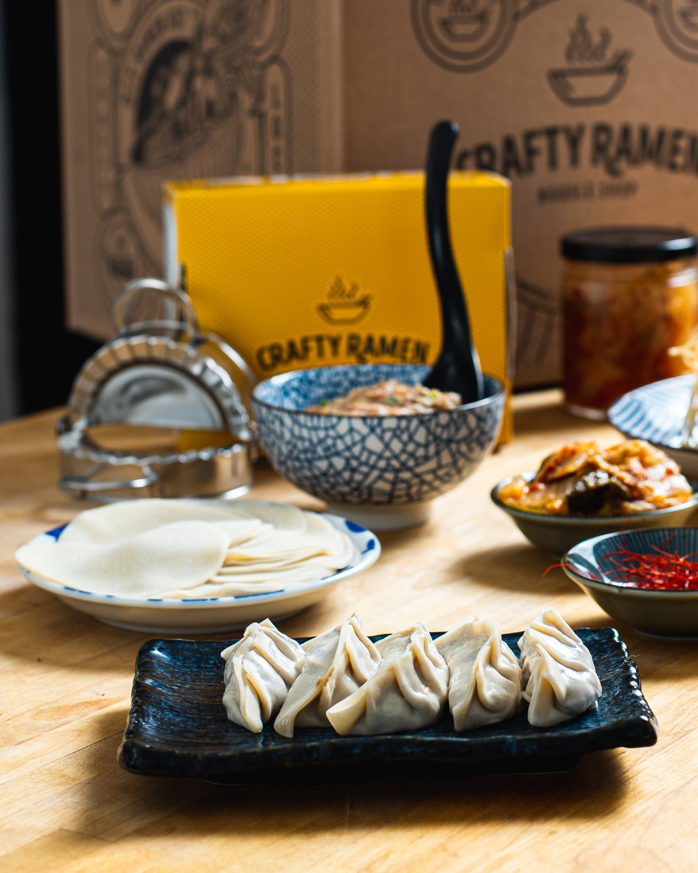 Folded gyoza in the foreground with mise en place in the background