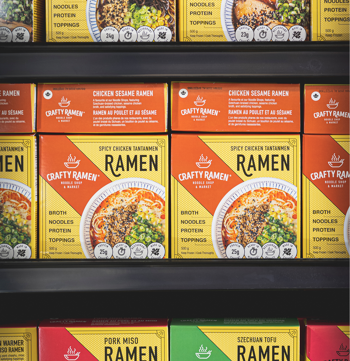 Shelves stocked with various Crafty Ramen boxes in different flavors, including Chicken Sesame Ramen and Spicy Chicken Tantanmen varieties.