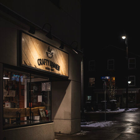 Dimly lit street scene of Crafty Ramen restaurant with sign at night