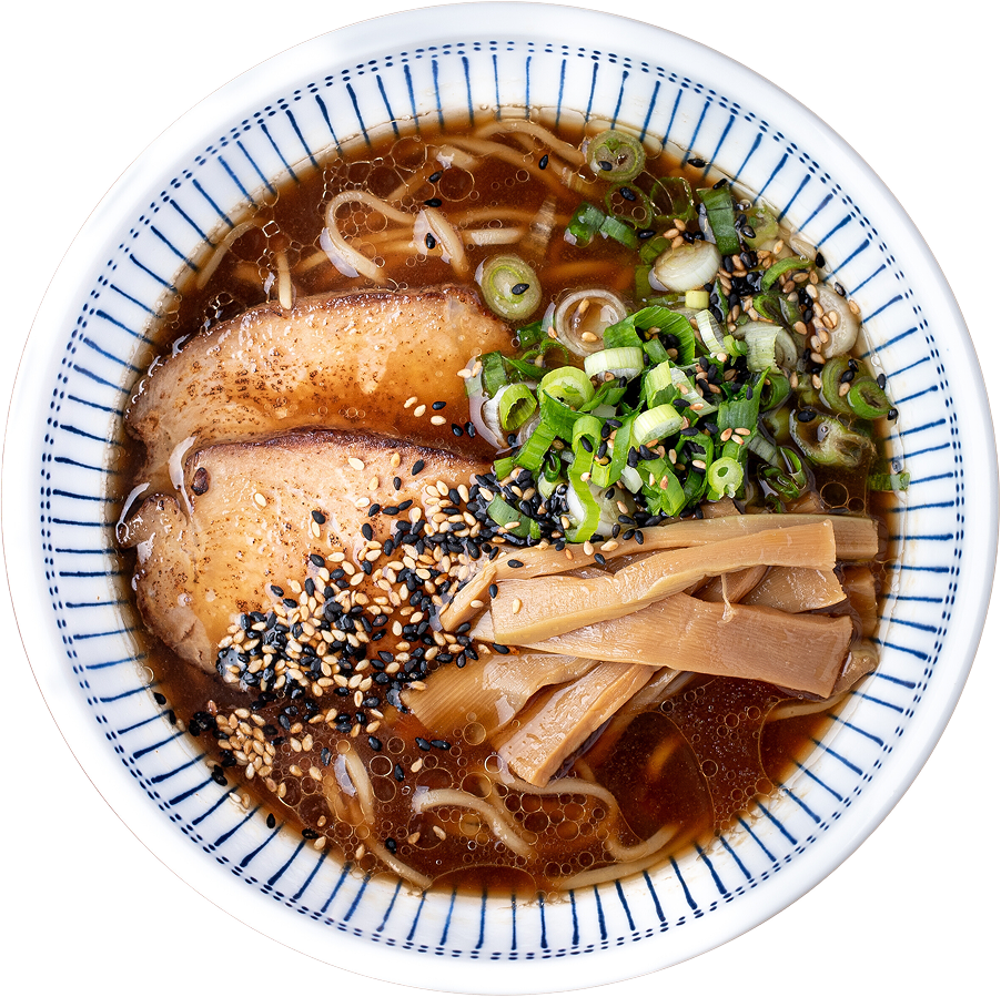 A finished bowl of pork shoyu ramen with sliced pork chashu, scratch-made noodles, real bone broth, green onion, bamboo shoots, white sesame seeds, and black sesame seeds arranged on a blue and white striped bowl photographed from above.