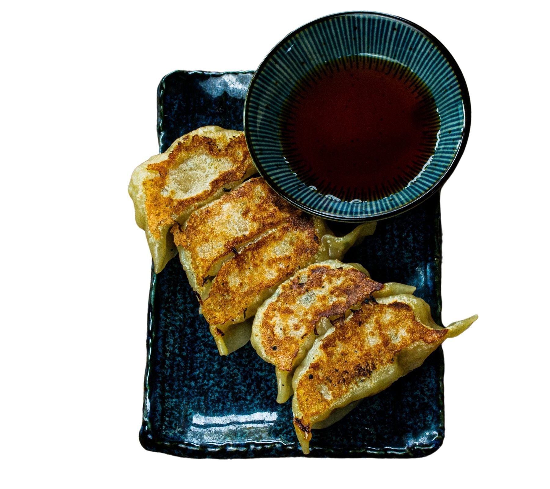 Plated fried gyoza with a side of sauce
